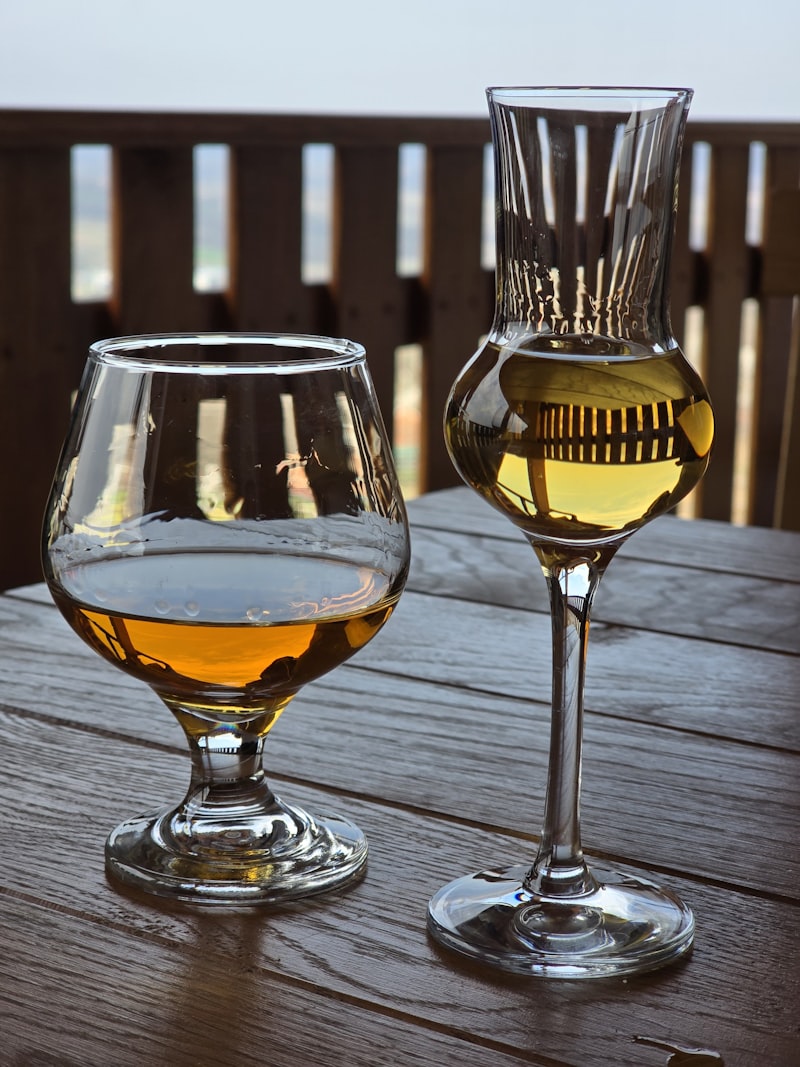 Deux verres de Bas-Armagnac posés sur une table en bois